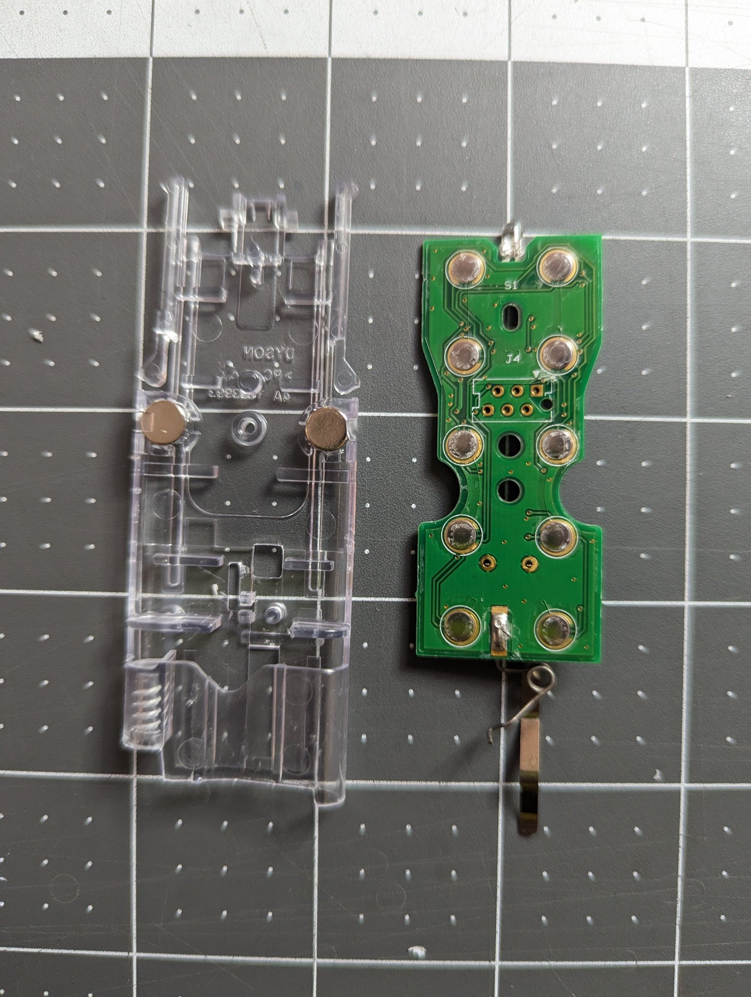 The front of the remote PCB with plastic housing containing magnets